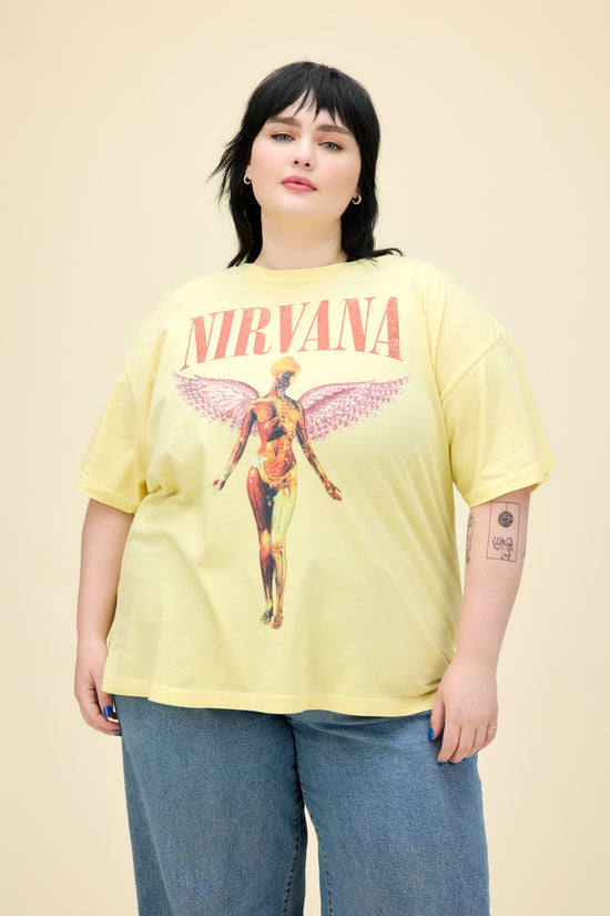 A model featuring a plus size yellow mist colored merch tee stamped with Nirvana's Utero album cover.