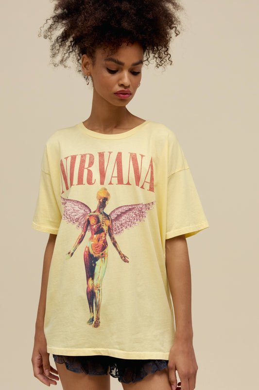 A model featuring a yellow mist colored merch tee stamped with Nirvana's Utero album cover.