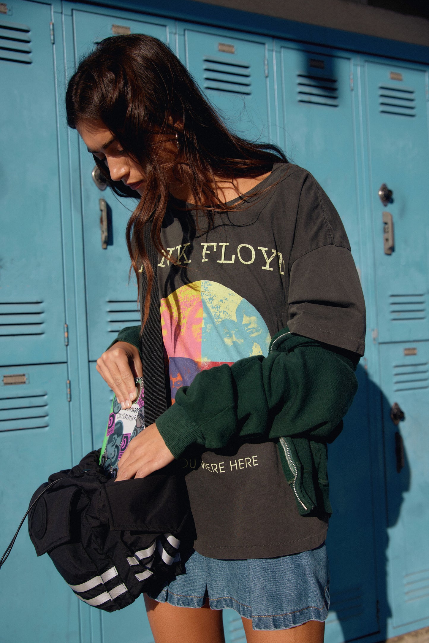 A model featuring a black tee stamped with "Pink Floyd" and a collage picture of the band.
