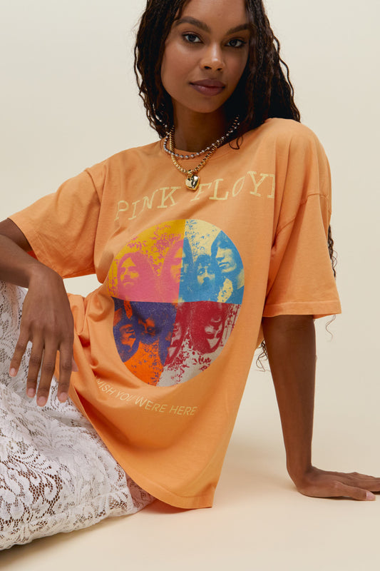 A model featuring a vintage peach tee stamped with "Pink Floyd" and a collage picture of the band.