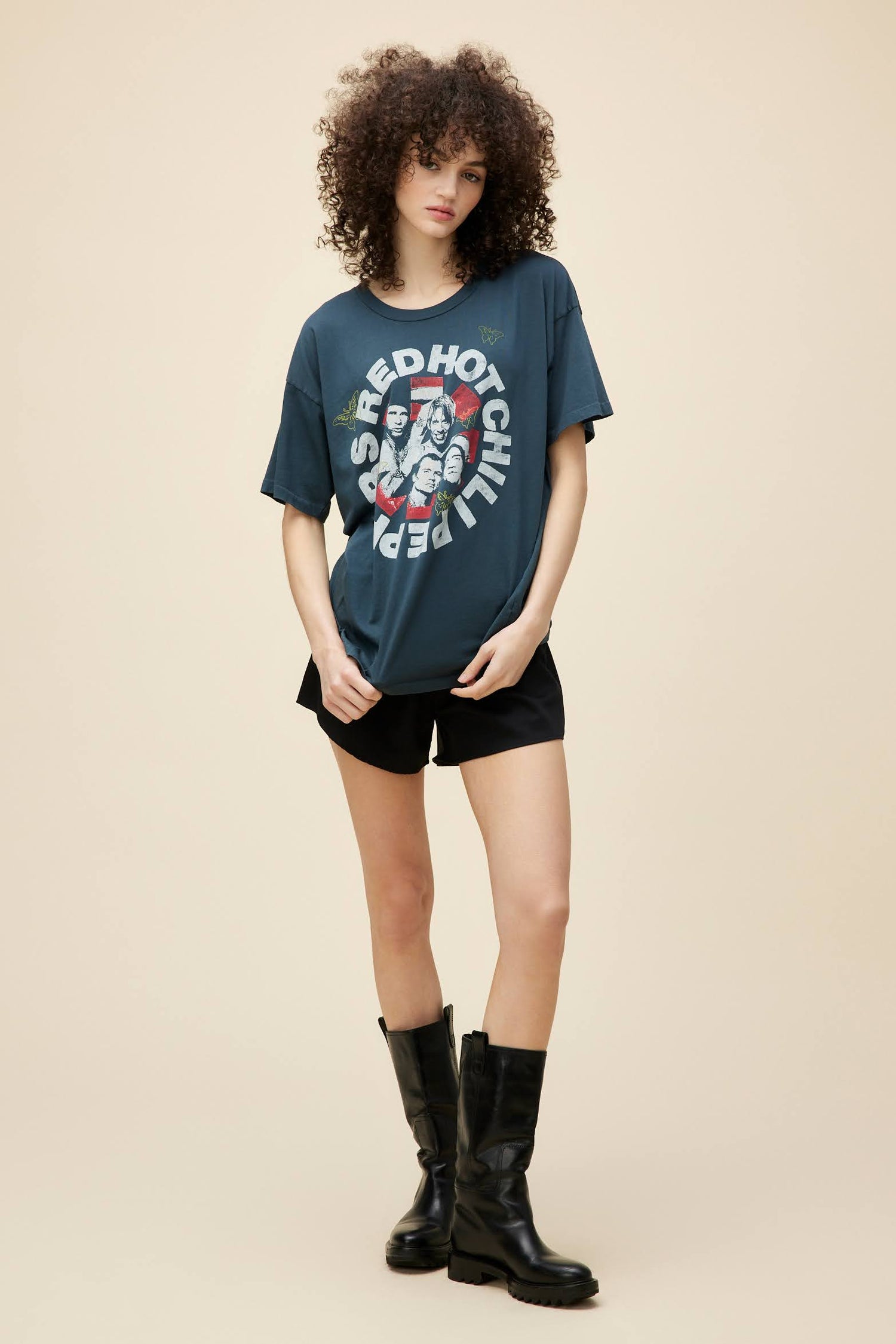 Curly-haired model wearing an oversized Red Hot Chili Peppers graphic tee.