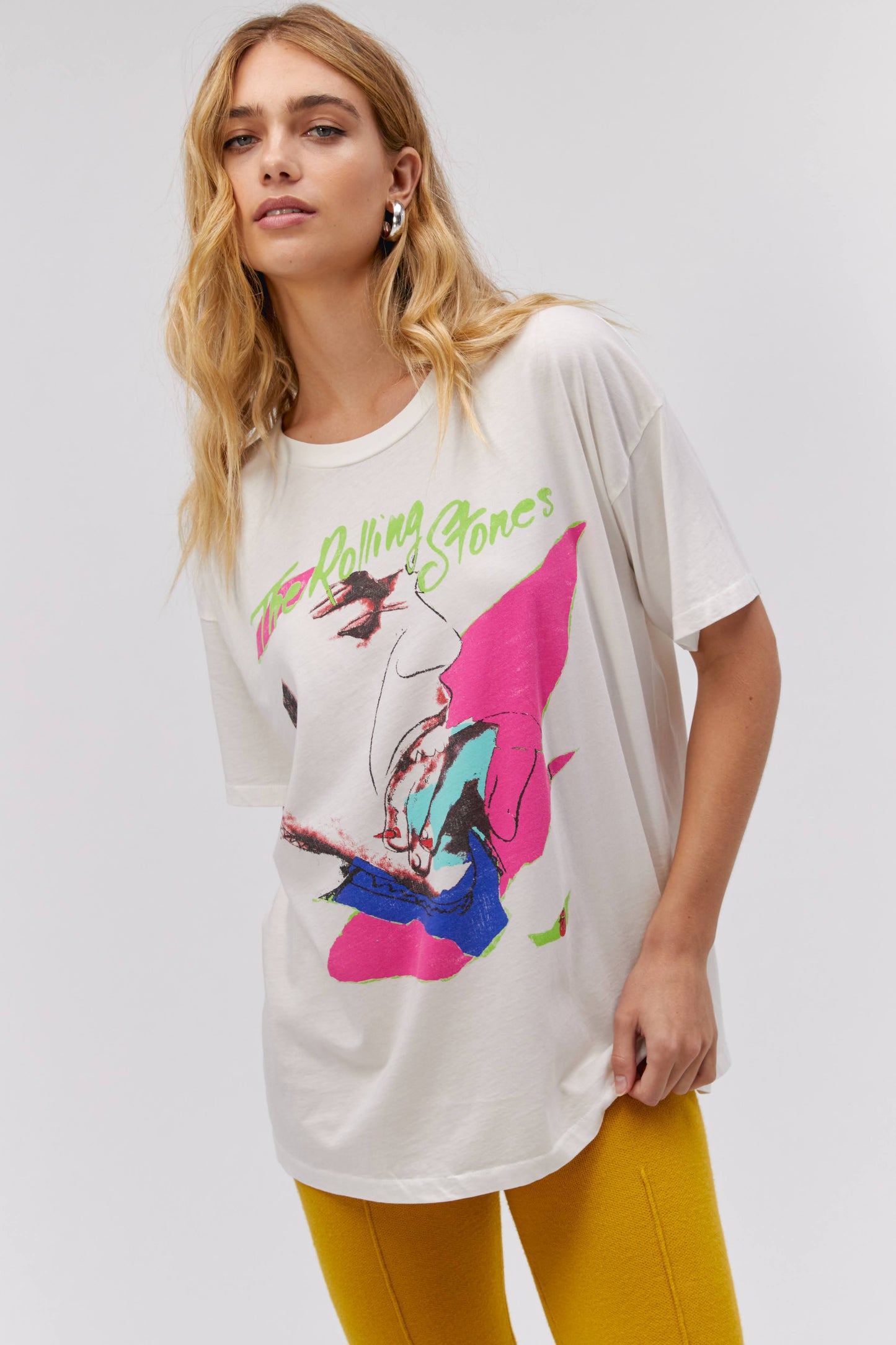 A blonde-haired model featuring a white tee designed with the Rolling Stones album cover, Love You Live.
