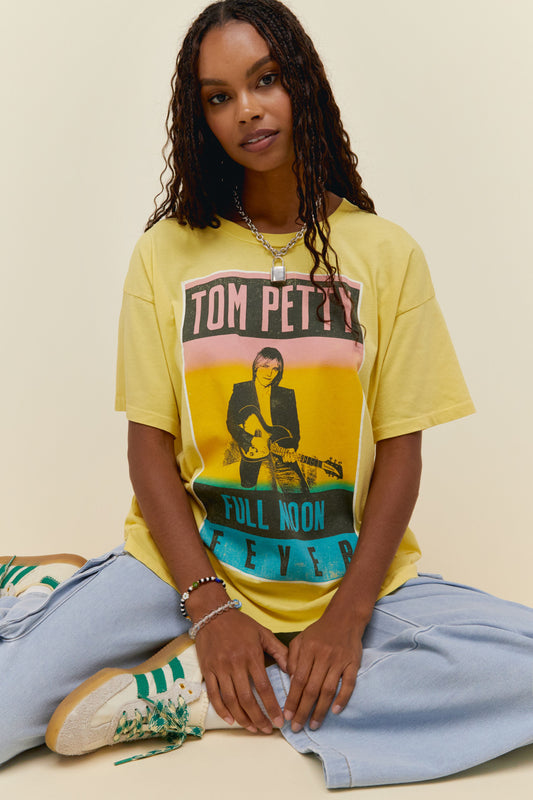 A dark-haired model featuring a yellow tee with a graphic of Tom Petty's Full Moon Fever album art