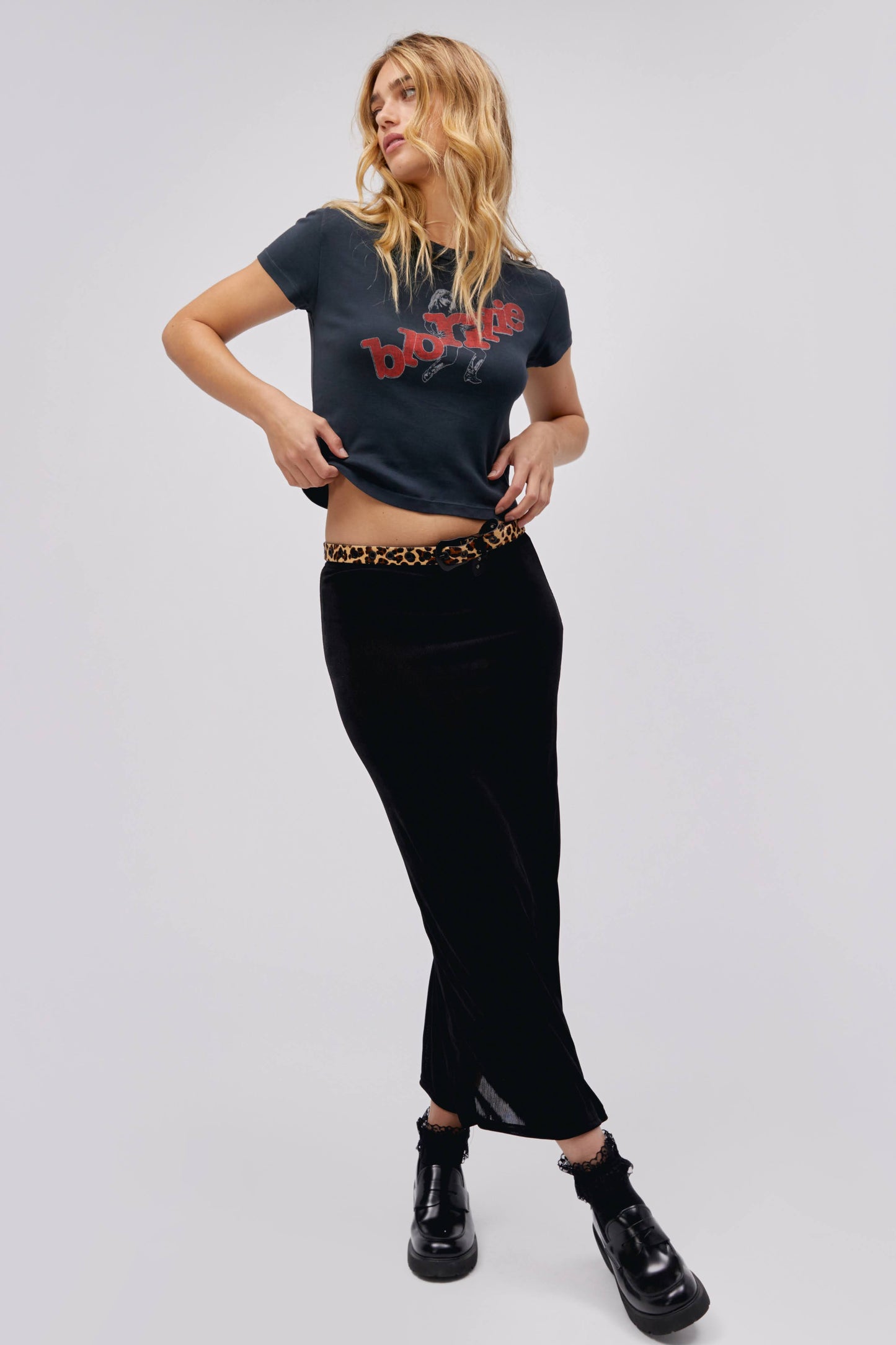 A blonde-haired model featuring a black tee stamped with 'blondie' in red, scattered letters.