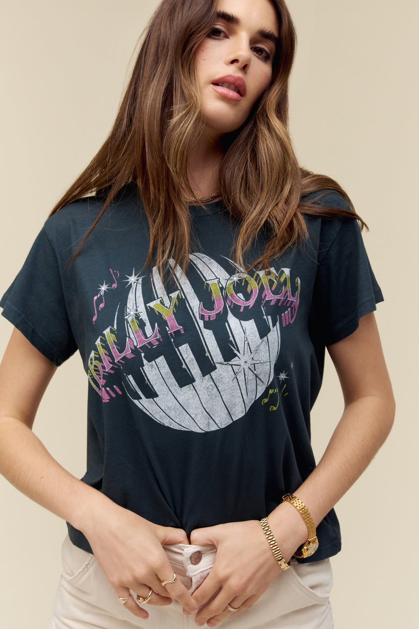 A dark-haired model featuring a black tee designed with piano keys wrapped around a disco ball and the icon’s name spelled out in bold text.