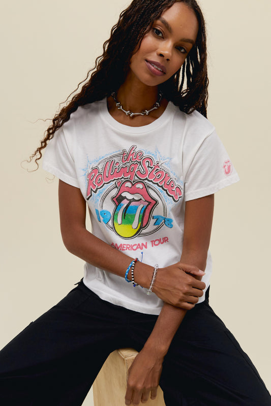 A dark-haired model featuring a white tee designed with the classic Rolling Stones logo in the center