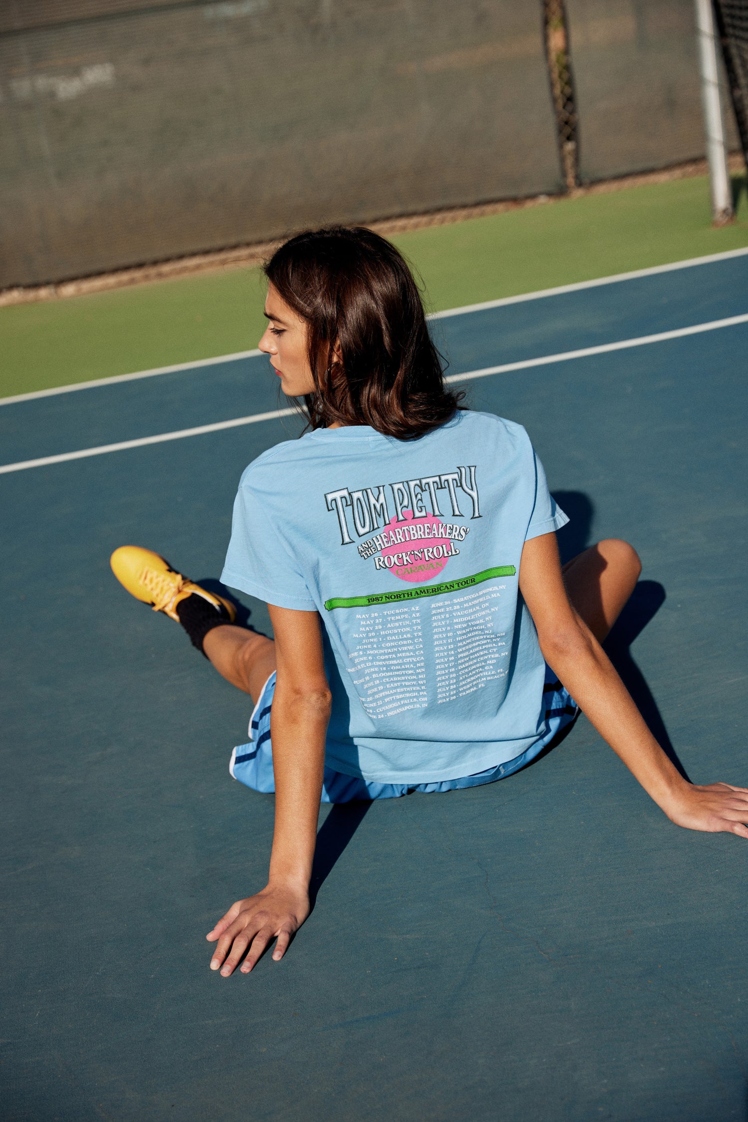 A model featuring a vintage blue solo tee  stamped with 'Tom Petty' and designed with pine trees on each side