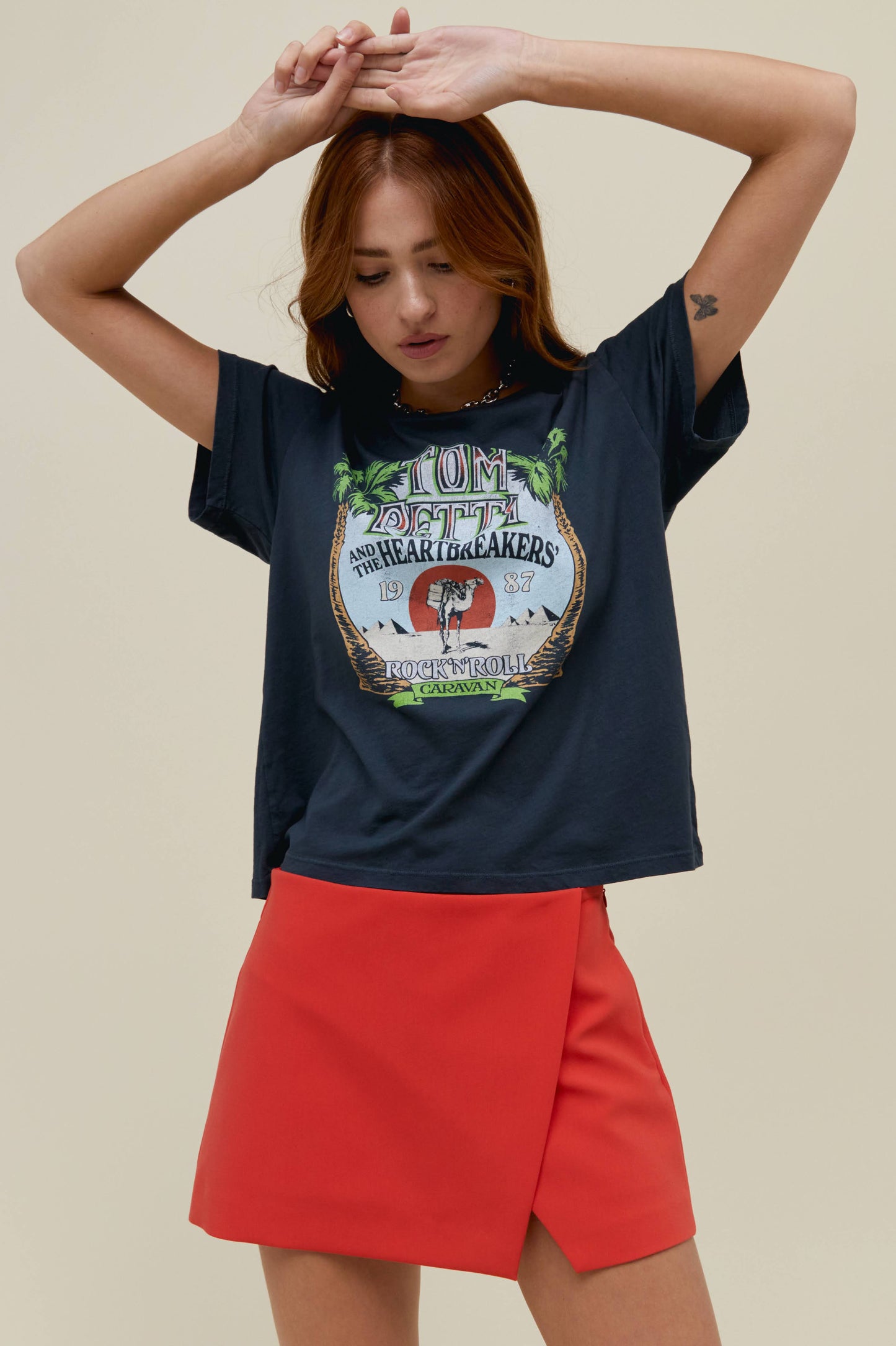 A model featuring a vintage black solo tee  stamped with 'Tom Petty' and designed with pine trees on each side