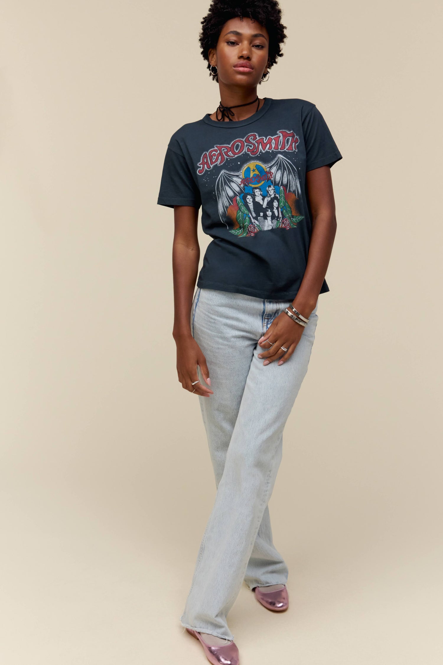 A model featuring a black tee stamped with Aerosmith and a photo of the band in the middle.