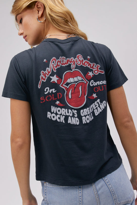 A blonde-haired model featuring a vintage black tee stamped with 'The Rolling Stones' and designed with an iconic group photo of the band.