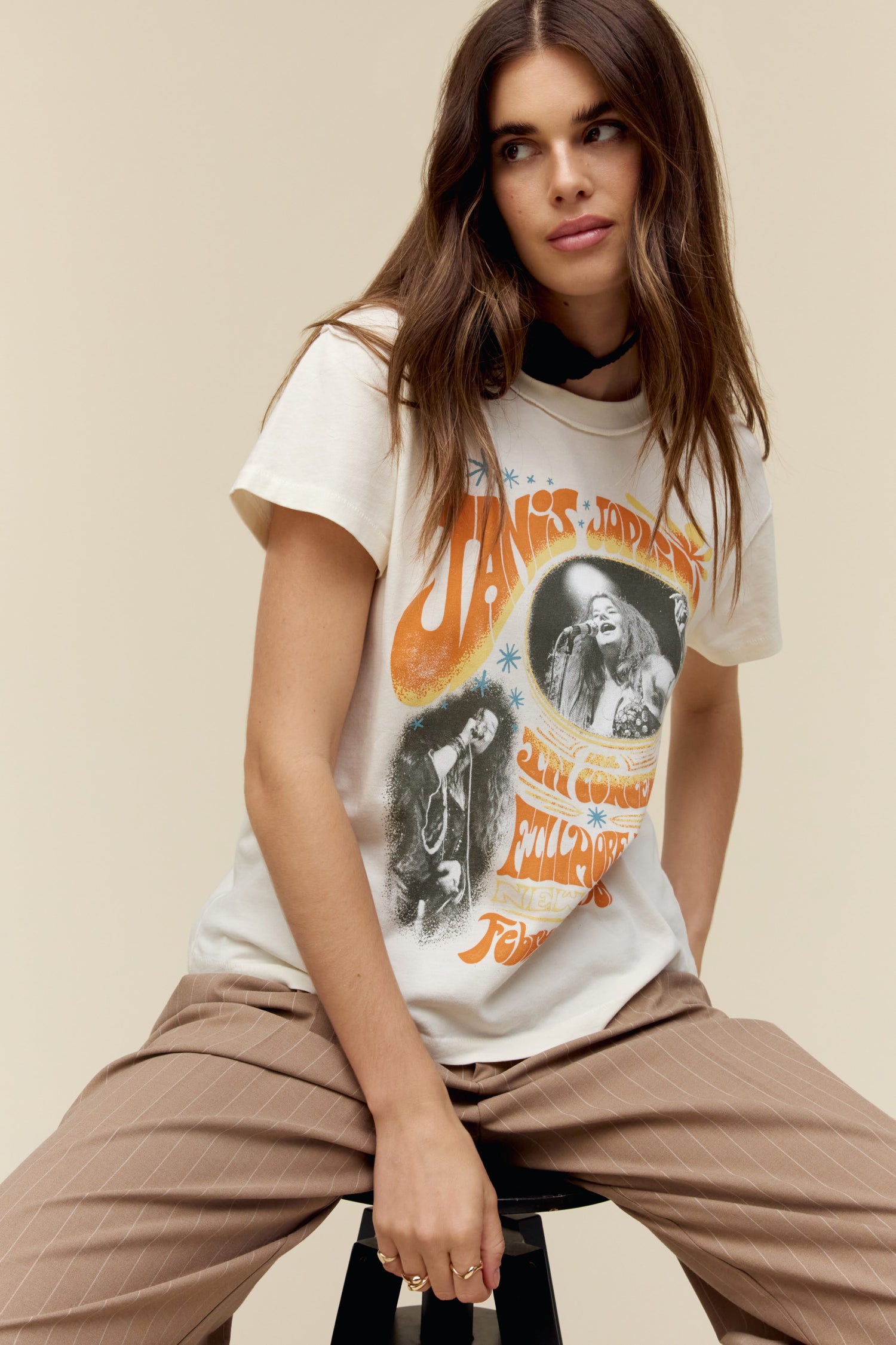 A model featuring a white tee stamped with Janis Joplin and stamped with the portraits of the artist.
