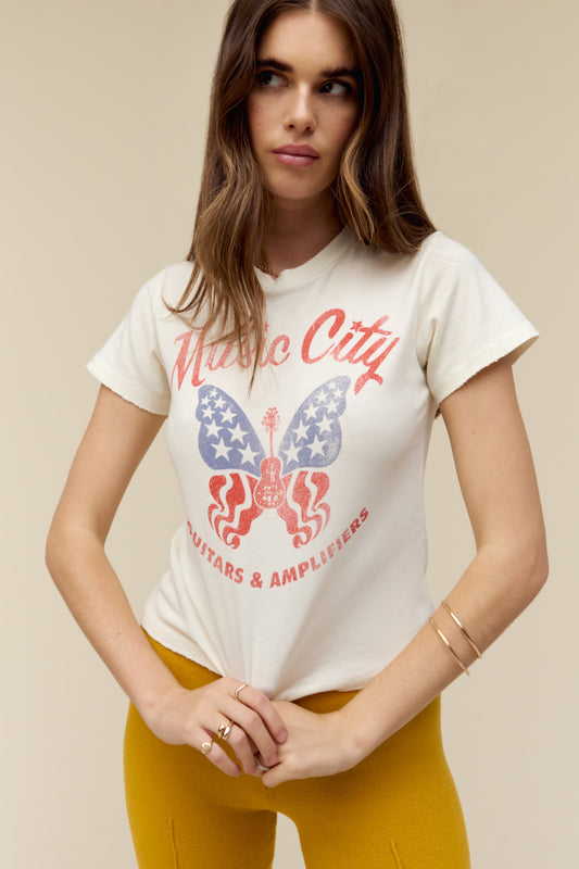 Model wearing a vintage-inspired t-shirt with a distressed 'Music City' graphic featuring butterfly and guitar artwork