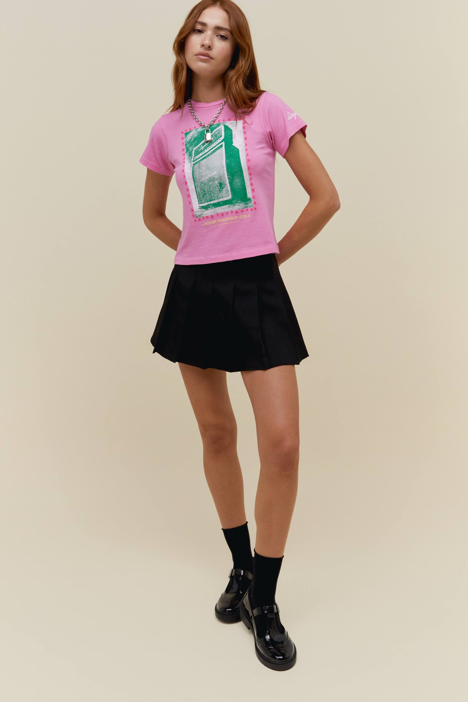 A model featuring a pink vintage tee with a distressed amp graphic.