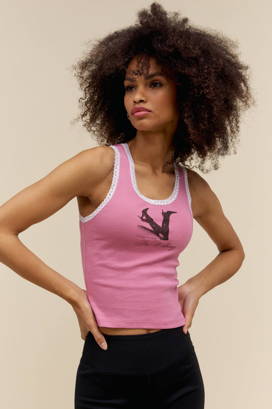 A model featuring a pink lace  trim tank with  graphic heels in front.