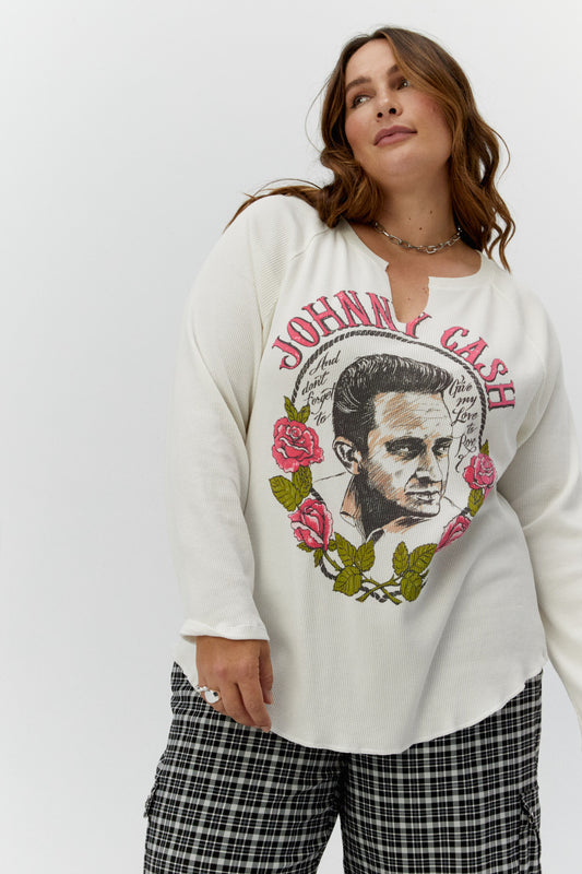 Brown curly-haired plus size model featuring a white thermal designed with an authentic, sketched portrait of the country icon framed in roses with the single’s enduring lyrics stamped center, accented in hand-laid pink flocking