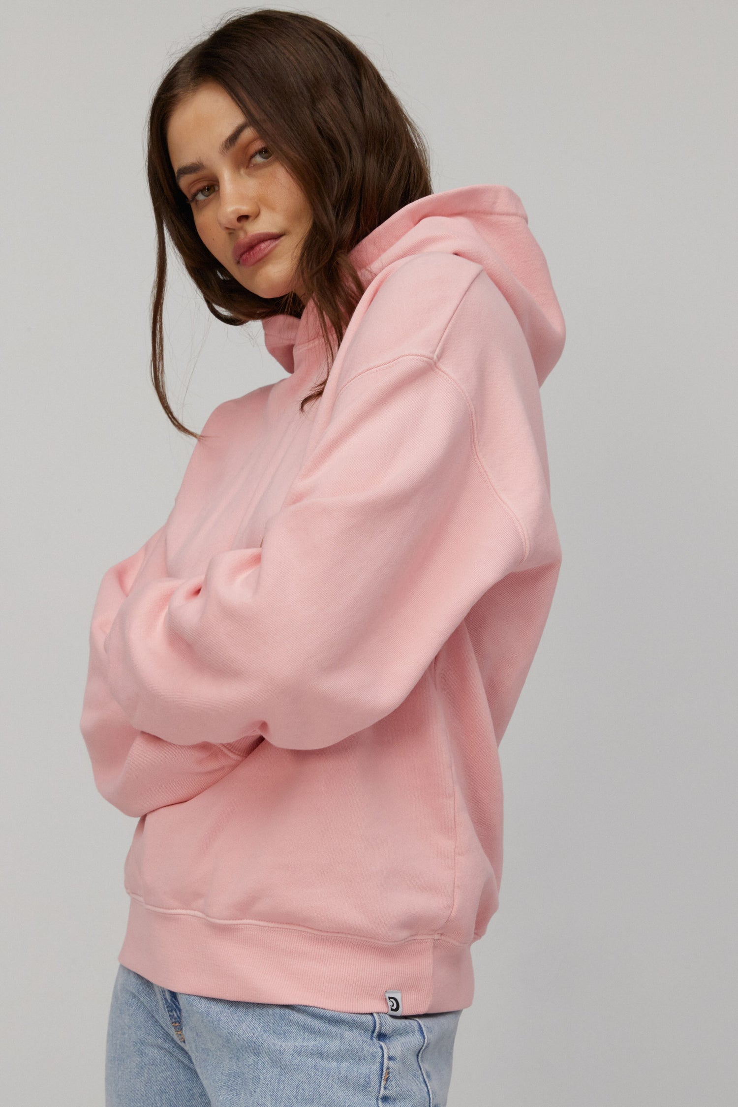 Dark-haired model featuring a pink-colored super soft and slightly oversized boyfriend hoodie