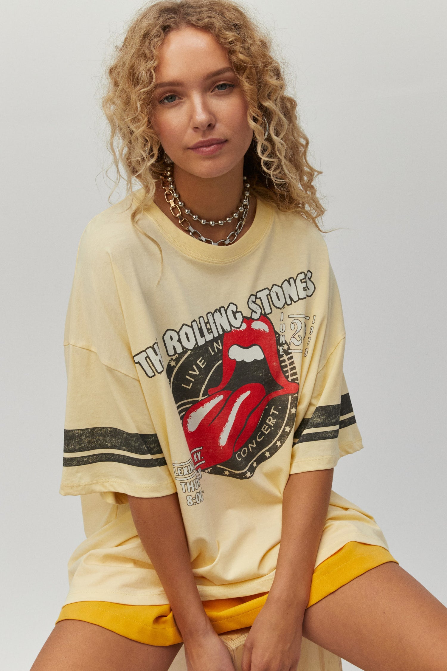 yellow tee designed with a stamp of the group’s hot lips logo