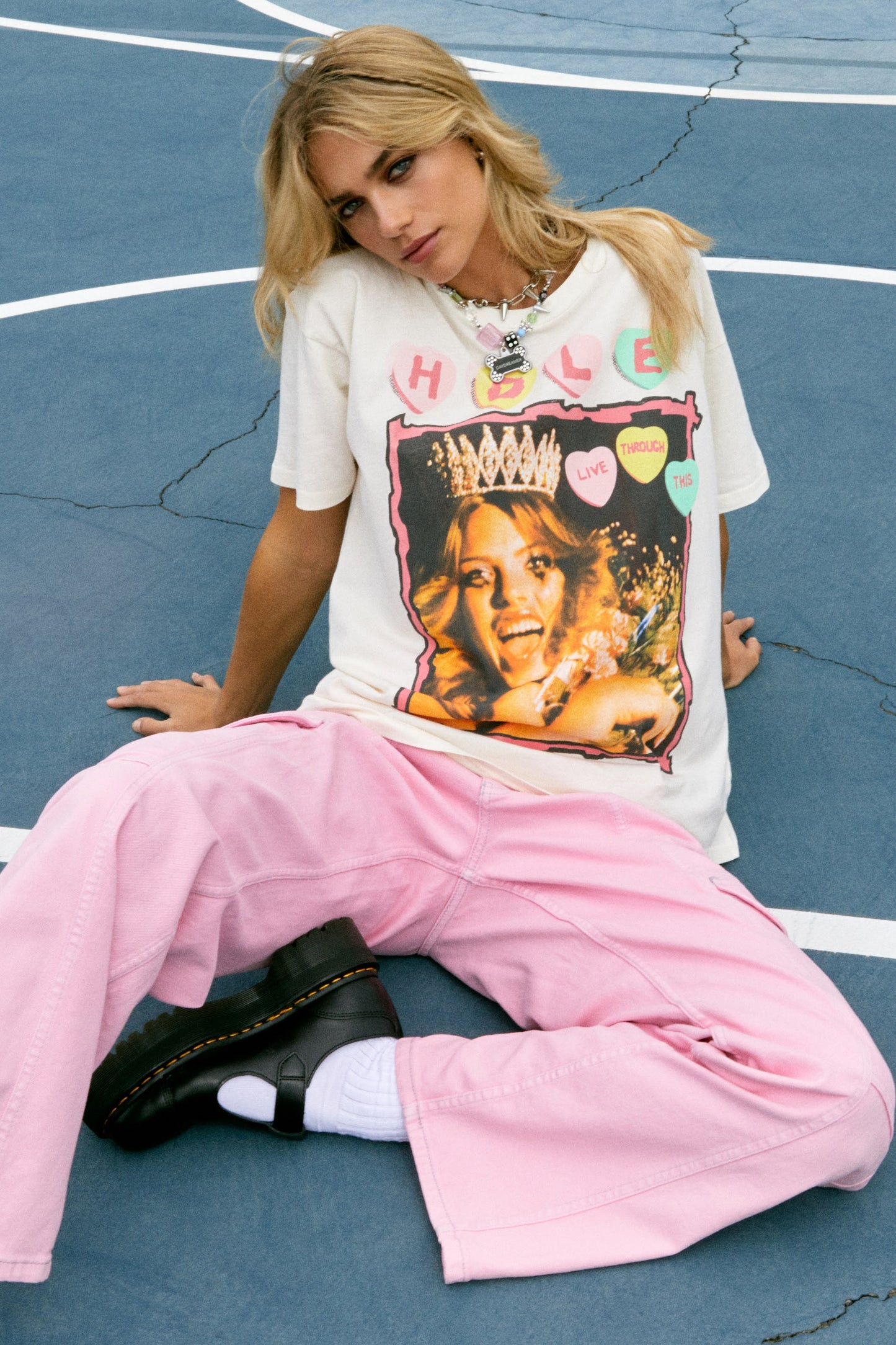 Blonde hair model in 90s Hole merch tee with grungy, poster style designed with the original artwork from Hole’s second studio album “Live Through This.” The tour details stamped along the back.