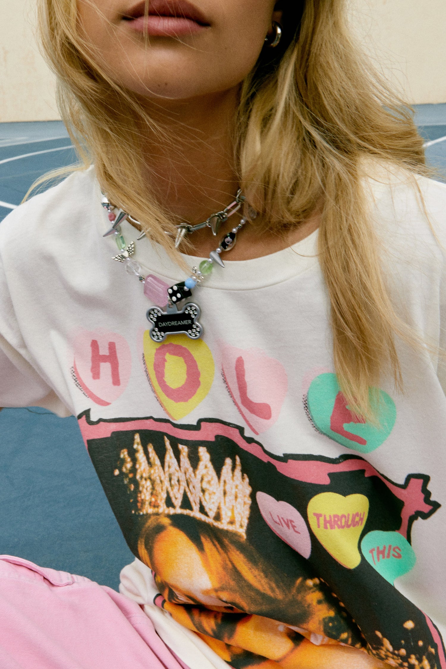 Blonde hair model in 90s Hole merch tee with grungy, poster style designed with the original artwork from Hole’s second studio album “Live Through This.” The tour details stamped along the back.